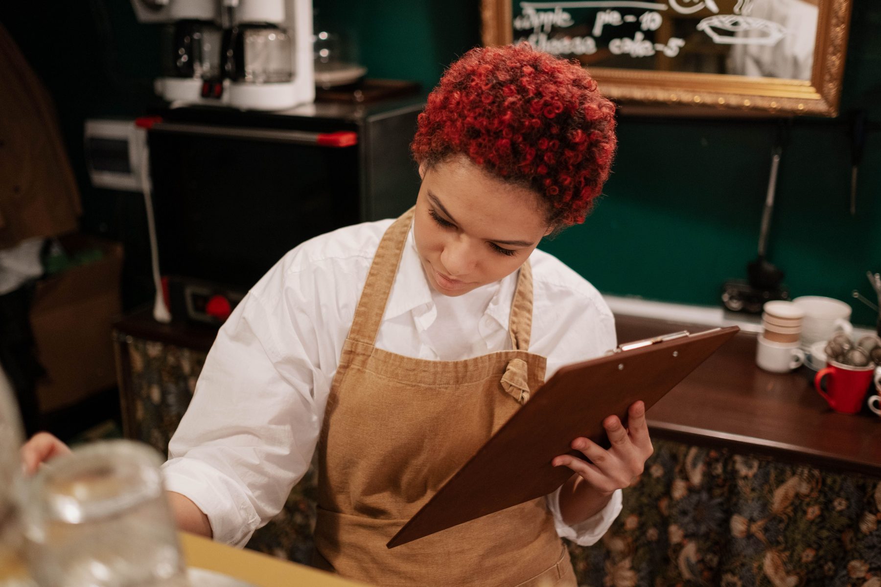 Restaurant team member reviewing a clipboard behind the counter