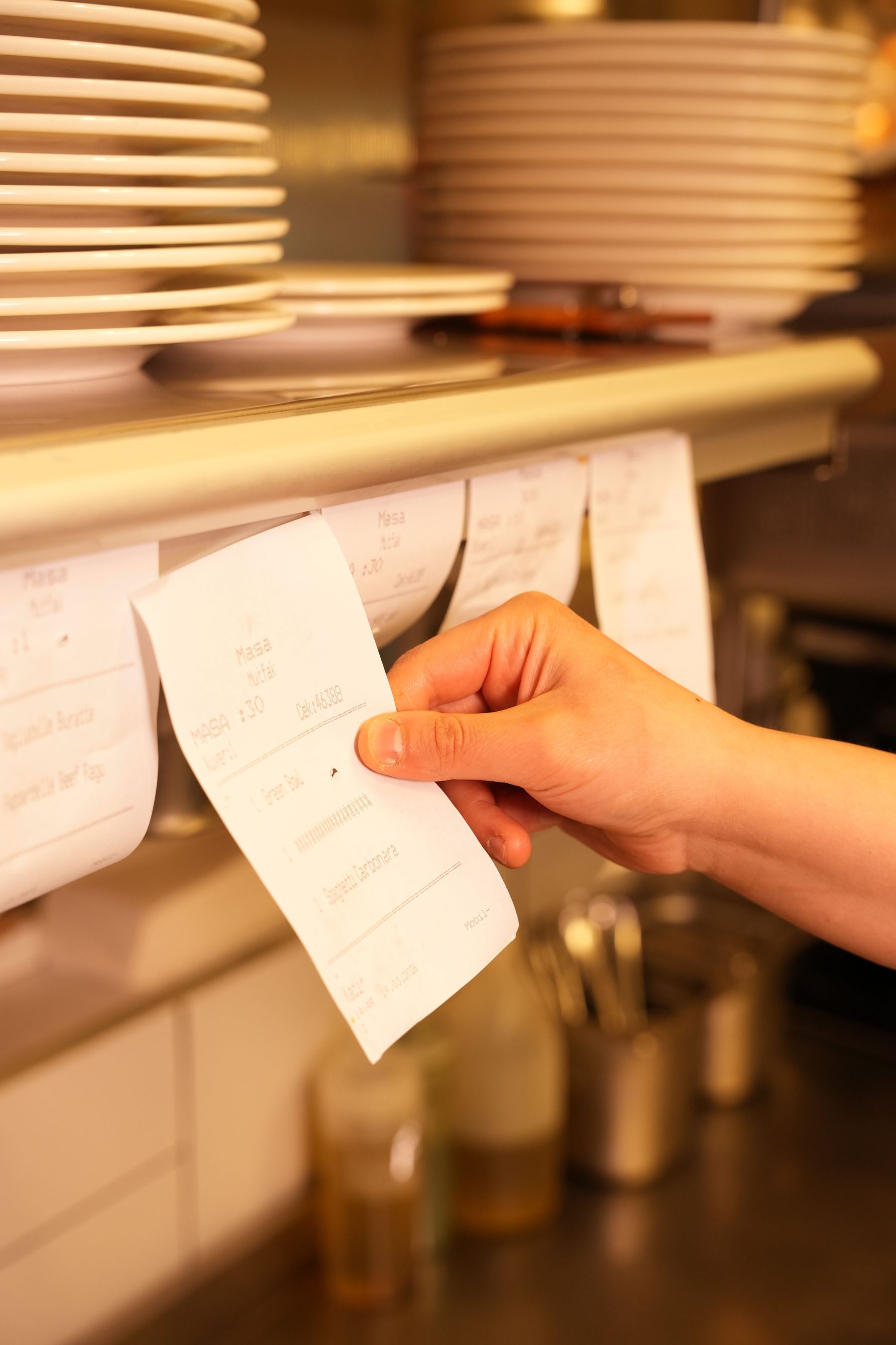 Kitchen tickets and plates at the pass