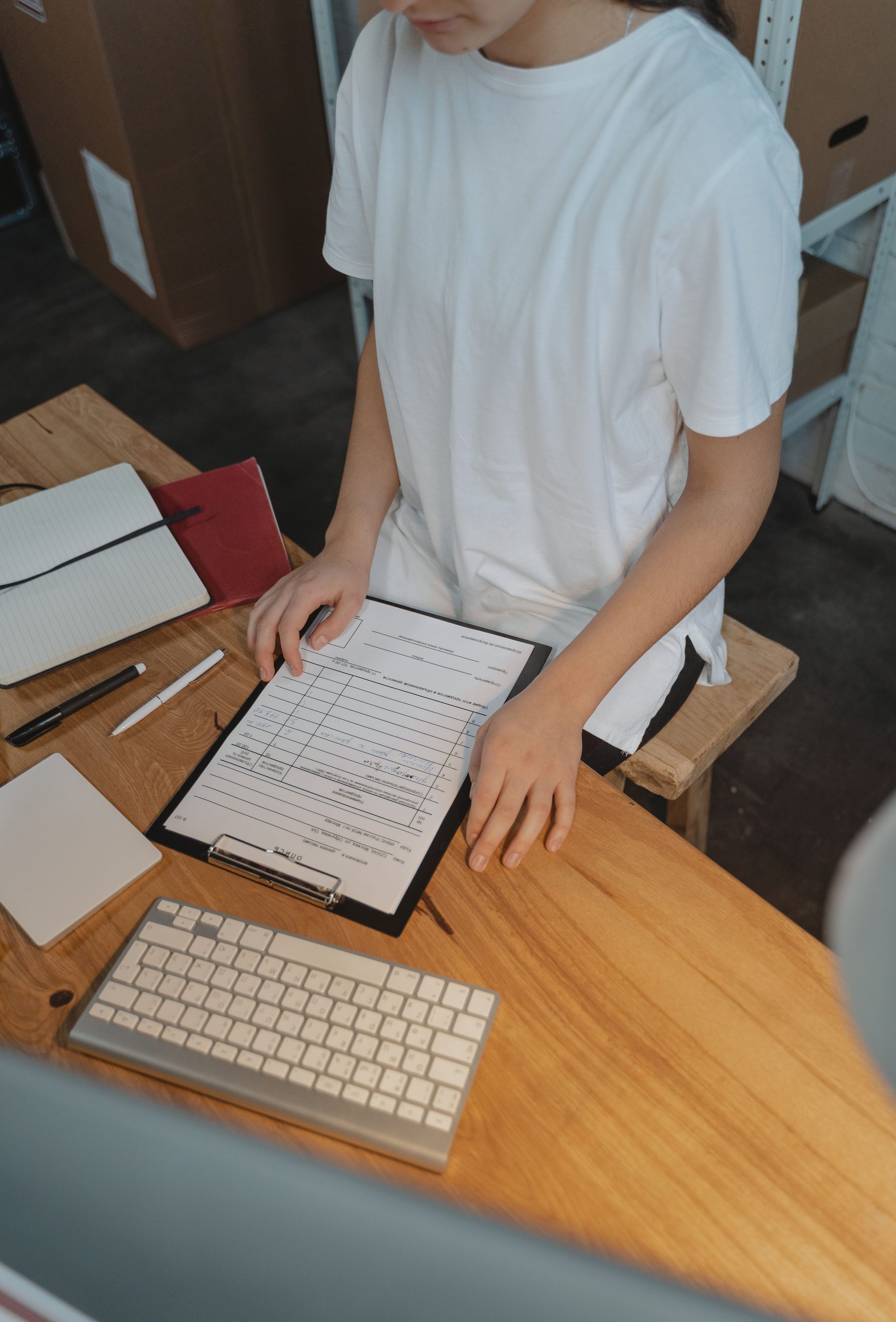 Restaurant paperwork and keyboard on a wood desk